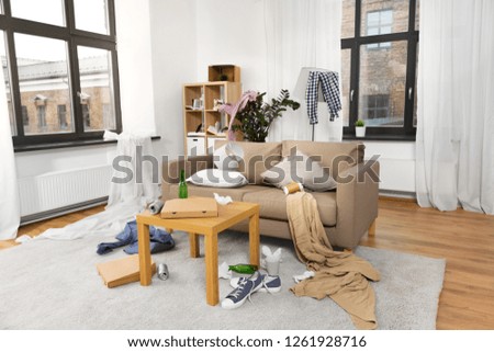 mess, disorder and interior concept - view of messy home living room with scattered stuff