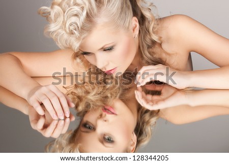 face and hands of beautiful woman with mirror