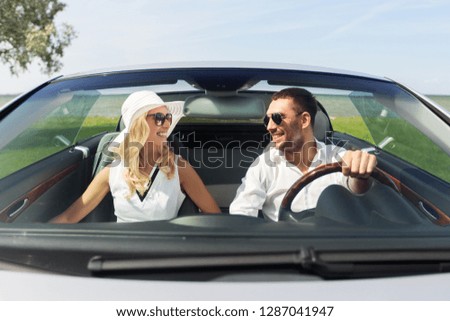 leisure, road trip, dating, couple and people concept - happy man and woman driving in cabriolet car outdoors