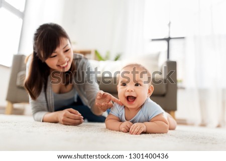 babyhood, childhood and people concept - happy little asian baby boy and mother at home
