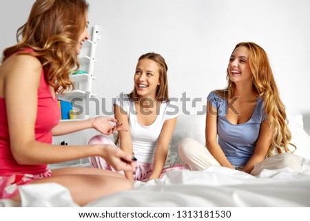 friendship, people, pajama party and communication concept - happy friends or teenage girls gossiping at home