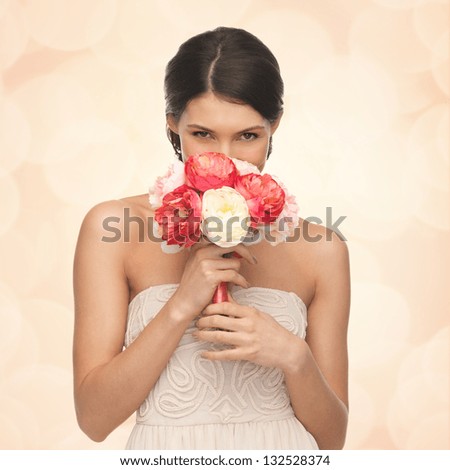 picture of young woman smelling bouquet of flowers
