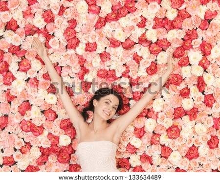 beautiful and young woman with background full of roses beautiful and young woman with background full of roses