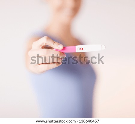 close up of woman holding pregnancy test