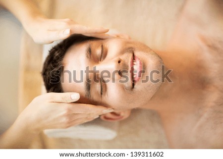 close up of man face in spa salon getting facial massage close up of man face in spa salon getting facial massage