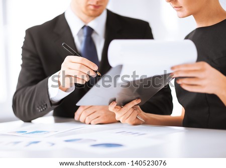 picture of businessman and businesswoman signing paper