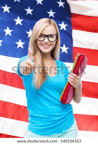 student with folders showing thumbs up over american flag