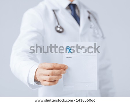Close Up Of Male Doctor Holding Rx Paper In Hand