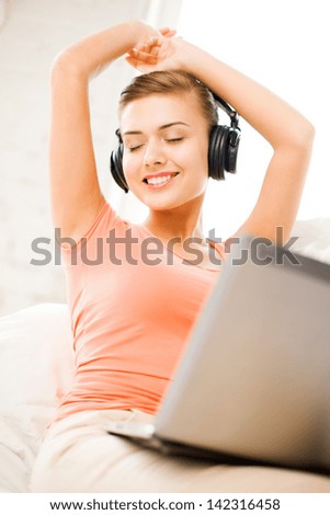 happy woman with headphones and laptop at home