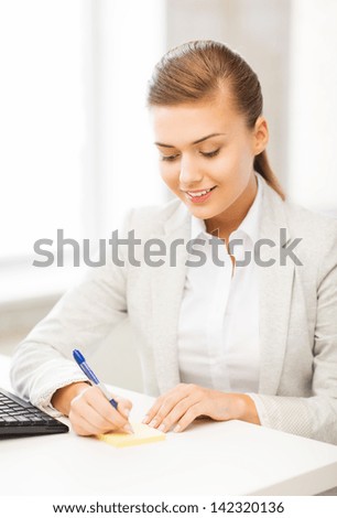 picture of businesswoman writing on sticky note