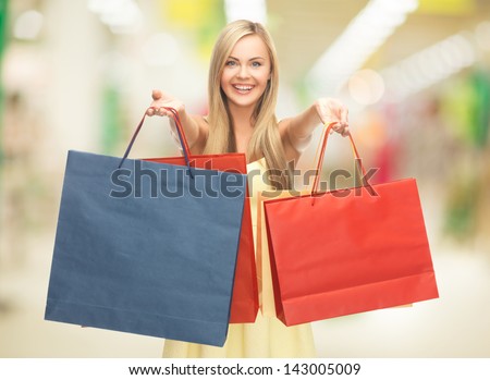 happy woman with shopping bags at the mall