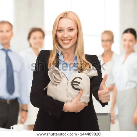 businesswoman with money bags showing thumbs up in office