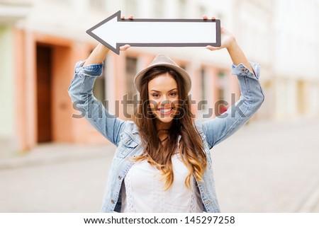 Holidays And Tourism Concept - Beautiful Girl Showing Direction With Arrow In The City