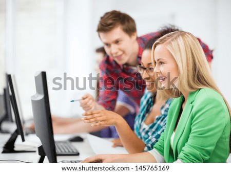 education concept - students with computer studying at school