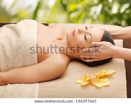 spa and holidays - woman in spa getting facial massage