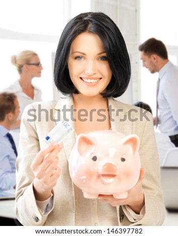 business and money saving concept - woman with piggy bank and cash money