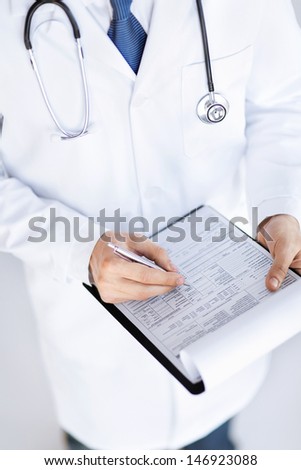 close up of male doctor holding prescription paper in hand