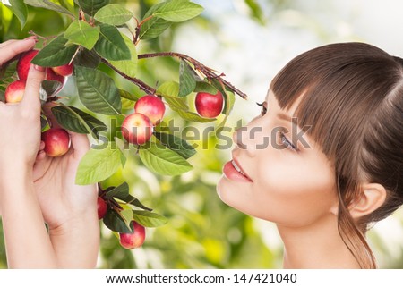 eco, bio and organic concept - beautiful woman with apple twig