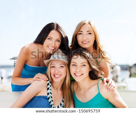 summer holidays and vacation - group of girls in cafe on the beach