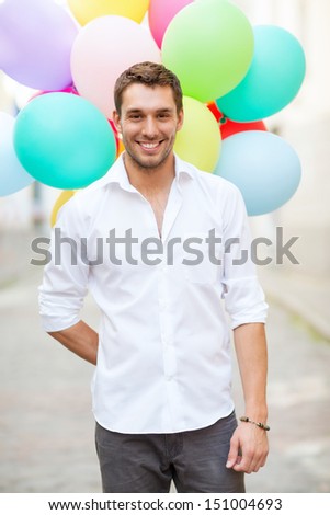 summer holidays, celebration and lifestyle concept - man with colorful balloons in the city