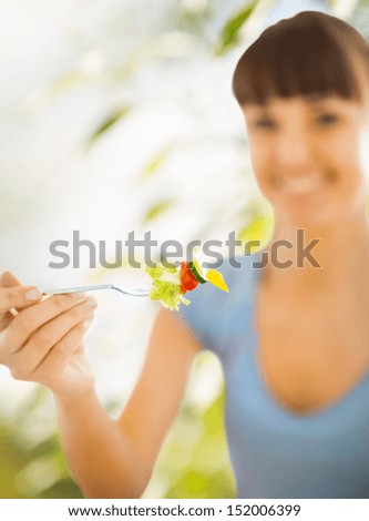 healthy food and dieting concept - woman hand holding fork with vegetables