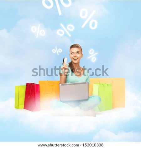 internet shopping and future technology concept - woman with laptop, shopping bags and credit card on the cloud