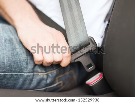 Transportation And Vehicle Concept - Man Fastening Seat Belt In Car