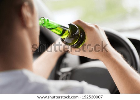 transportation and vehicle concept man drinking alcohol while driving the car transportation and vehicle concept man drinking alcohol while driving the car