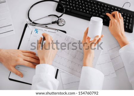 healthcare, hospital and medical concept - two doctors prescribing medication