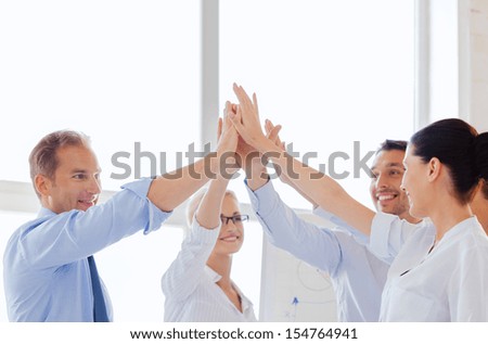 success and winning concept - happy business team giving high five in office