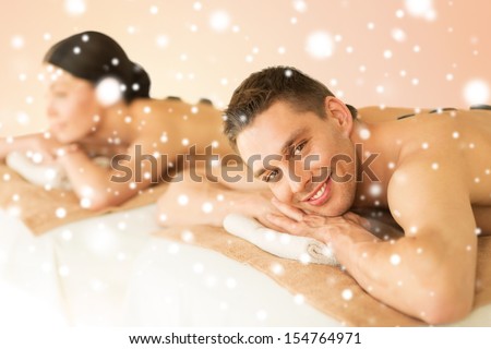 health and beauty, honeymoon and vacation concept - couple in spa salon with hot stones