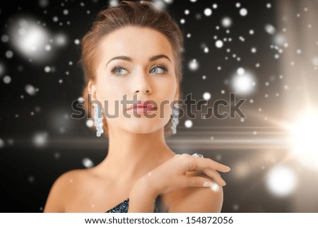 Jewelry, Luxury, Vip, Nightlife, Party Concept - Beautiful Woman In Evening Dress Wearing Diamond Earrings