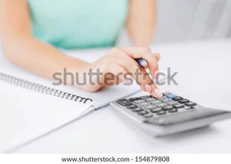 Business Concept - Businesswoman Working With Calculator In Office