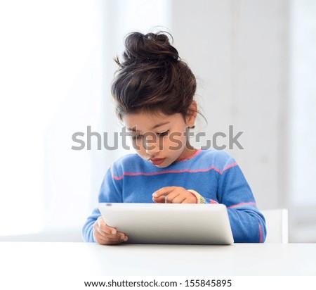 education, school, technology and internet concept - little student girl with tablet pc at home