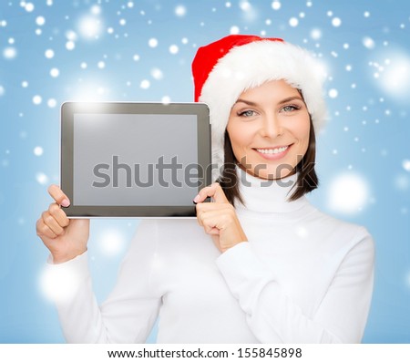 christmas, x-mas, electronics, gadget concept - smiling woman in santa helper hat with blank screen tablet pc