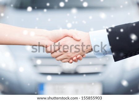 transportation, business, shopping and ownership concept - customer and salesman shaking hands outside