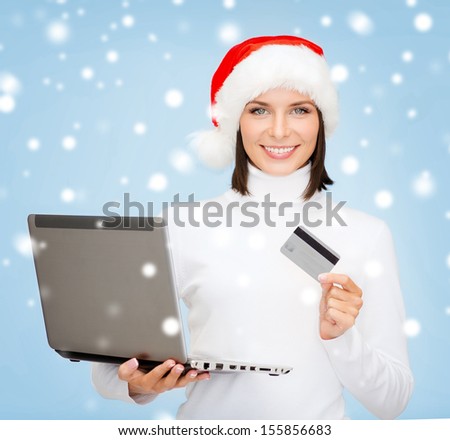 christmas, x-mas, online shopping concept - woman in santa helper hat with laptop computer and credit card