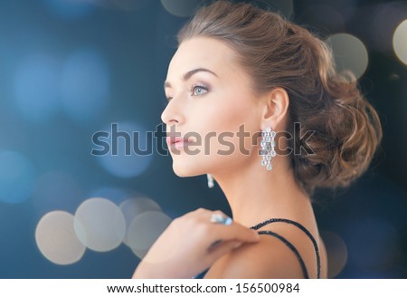 Jewelry, Luxury, Vip, Nightlife, Party Concept - Beautiful Woman In Evening Dress Wearing Diamond Earrings