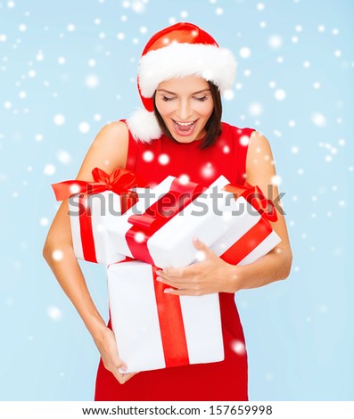 christmas, x-mas, winter, happiness concept - surprised woman in santa helper hat with many gift boxes