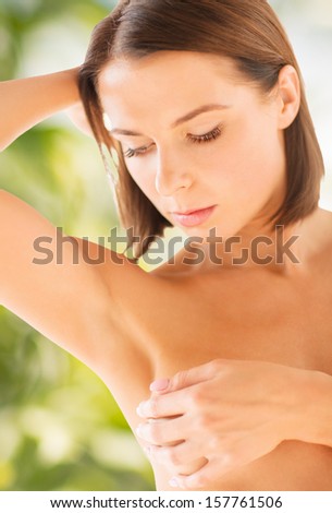 health and beauty, eco, bio, nature concept - woman checking breast for signs of cancer