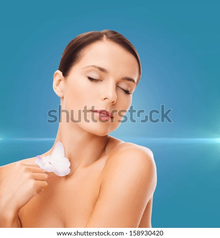 health and beauty concept - relaxed woman with orchid flower