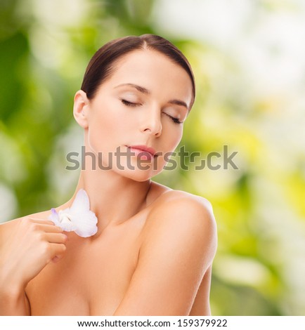 health and beauty, eco, bio, nature concept - relaxed woman with orchid flower