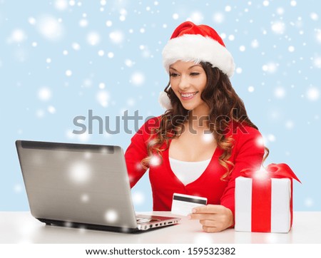 christmas, x-mas, online shopping concept - woman in santa helper hat with gift box, laptop computer and credit card