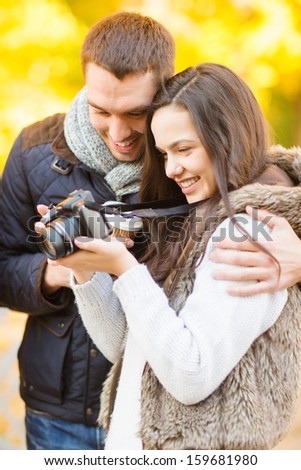 summer, holidays, vacation, travel, tourism, happy people, dating concept - couple with photo camera in autumn park