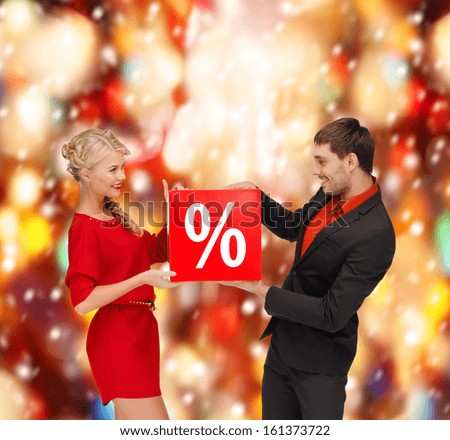 shopping, gifts, christmas, couple, x-mas concept - smiling woman and man with red percent sale sign