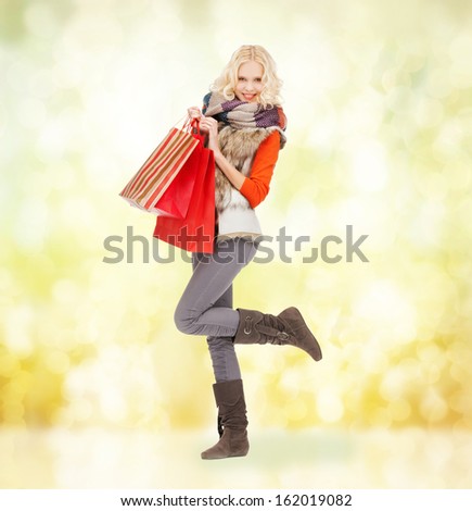 retail and sale concept - happy teenage girl in winter clothes with shopping bags