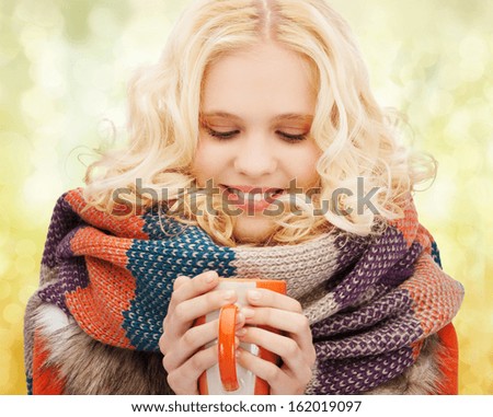 winter, people, happiness, drink and food concept - smiling teenage girl in warm clothes with tea or coffee mug