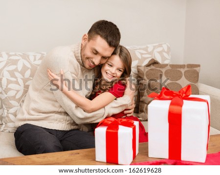 family, christmas, x-mas, winter, happiness and people concept - smiling father and daughter hugging