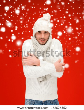 christmas, x-mas, winter, clothes concept - handsome man in warm sweater, hat and scarf