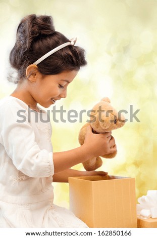 holidays, presents, christmas, x-mas, birthday concept - happy child girl with gift box and teddy bear